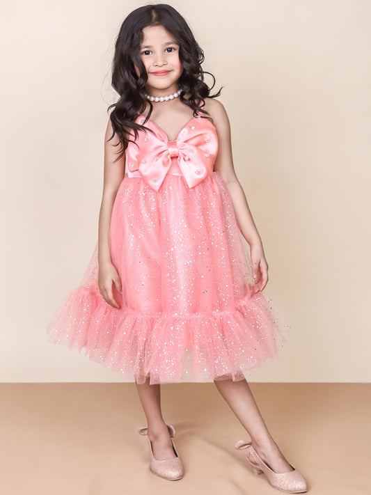 A stunning pink partywear dress for girls featuring a foil-printed tulle skirt, a satin bow bodice, and pearl-embellished straps. The dress has a sparkly, elegant look, making it perfect for birthdays, weddings, and festive occasions. Styled with pearl accessories and matching glitter heels for a glamorous finish.
