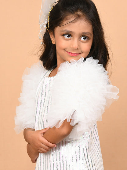 A young girl wearing a glamorous white sequin dress with voluminous tulle frill sleeves, paired with silver heels. The knee-length dress shimmers under the light, making it perfect for special occasions like parties and weddings. Ideal for B2B wholesale and white-label manufacturing by Sundaram Fashions.